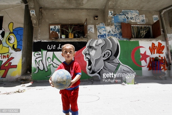 451183092-palestinian-boy-plays-with-a-ball-in-front-gettyimages