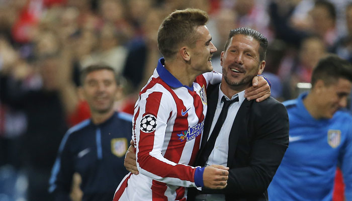 Atletico's Antoine Griezmann, left, celebrates with his coach Diego Simeone after scoring during the Group A Champions League soccer match between Atletico de Madrid and Malmo at the Vicente Calderon stadium in Madrid, Spain, Wednesday, Oct. 22, 2014. (AP Photo/Andres Kudacki)